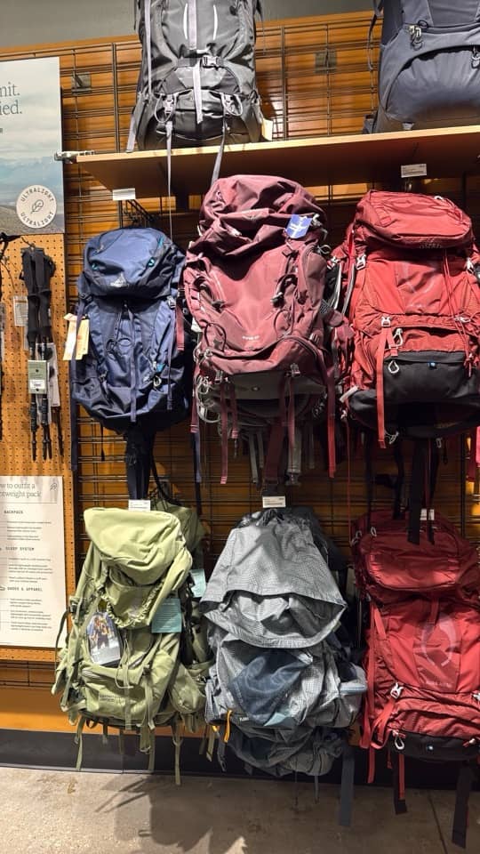 A wall of hiking backpacks at REI