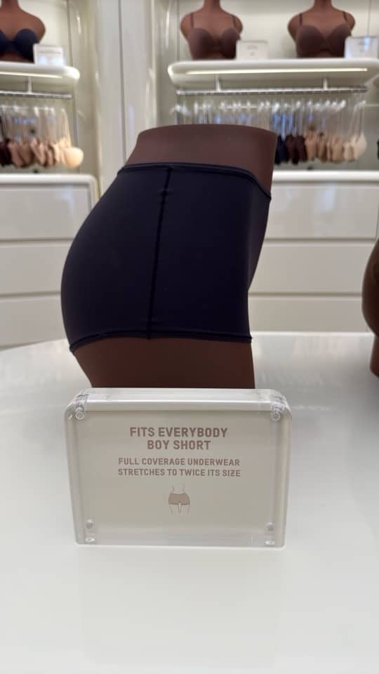 Calzón estilo short SKIMS Fits Everybody con un letrero sobre la modelo